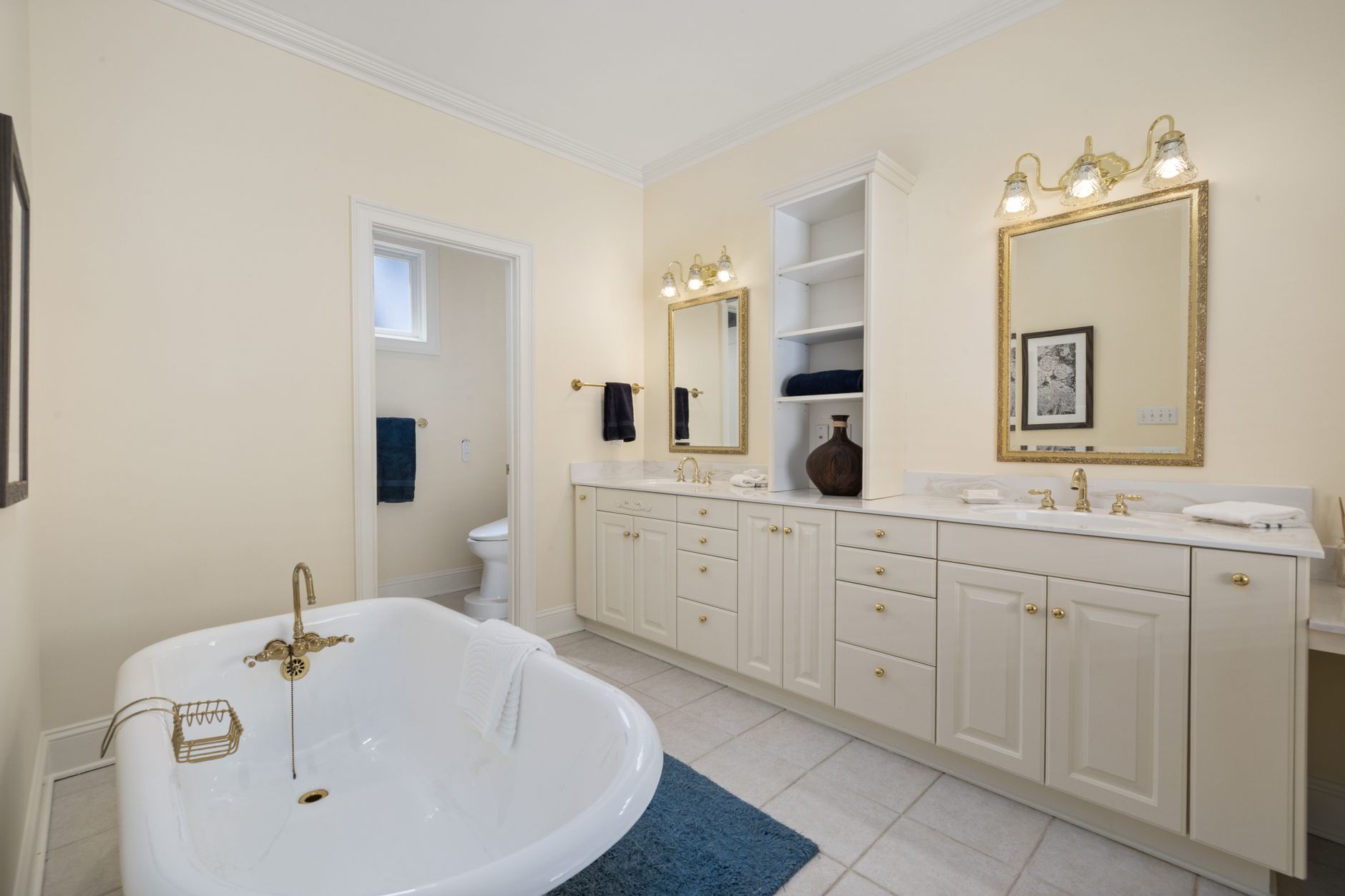 Luxurious bathroom featuring a classic clawfoot tub, double vanity, and warm lighting for a serene in Riverside, CA