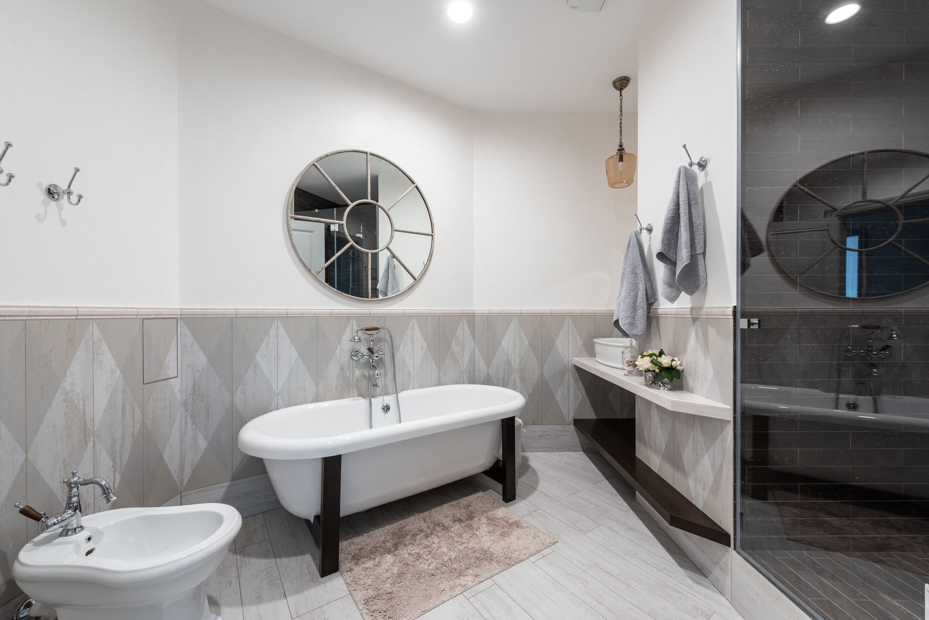 Interior of modern bathroom with glass shower and clean sink illuminated with bright lamp in Riverside, CA